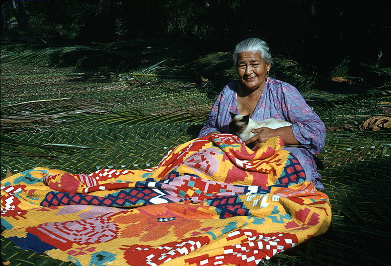 A Rarotonga native is pictured sewing a tivaevae. Photo Credit: John C. Burland, from the National Library of New Zealand